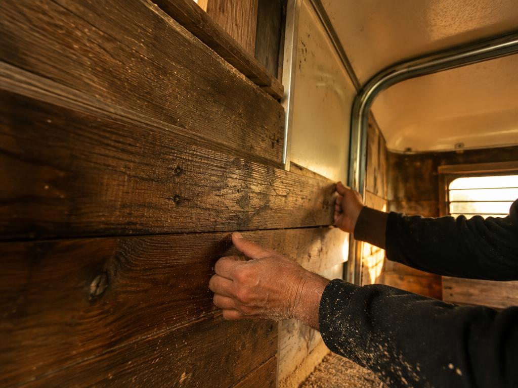 Reclaimed timber cladding being fitted by hand inside the converted horsebox